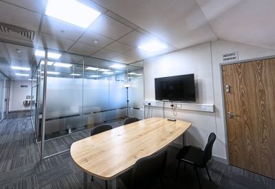 Reception area with wood-paneled doors and a frosted glass meeting room wall.