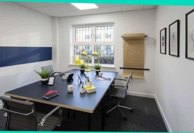 Private four-person office suite with black desks and a large window.