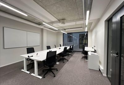 Large conference table with teal chairs in a room featuring floor-to-ceiling wooden shelving.