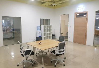 Small meeting room with a wooden table, four chairs, and a white storage unit.