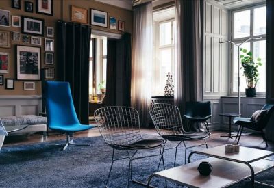 Artistic breakout space with an eclectic gallery wall and blue velvet chair.