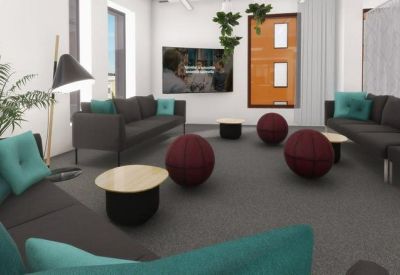 Lounge area with dark grey sofas, teal pillows, and large burgundy exercise ball chairs.