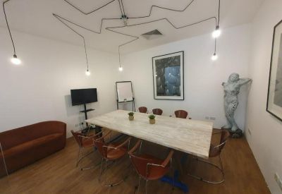 Stylish meeting room with a large marble-topped table and unique spider-style lighting.