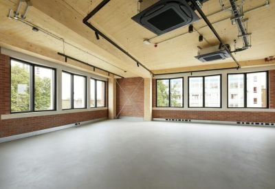 Contemporary kitchen and dining area with matte black cabinetry and light wood walls.