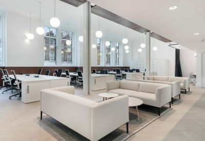 Spacious communal lounge with white sofas and globe pendant lighting.