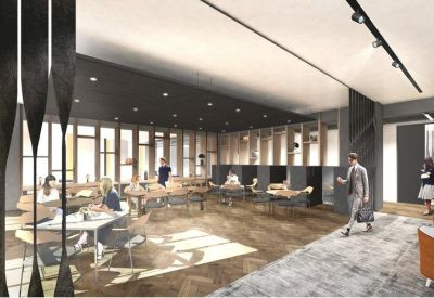 Sun-drenched open-plan workspace with wooden desks and decorative industrial screen dividers.