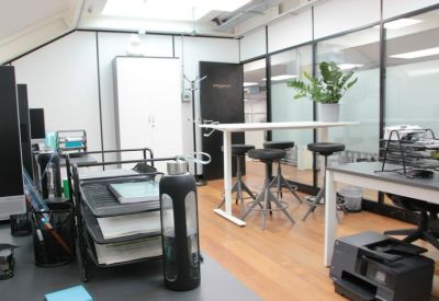 Bright open-plan office featuring a tall white storage cabinet and glass partitions.