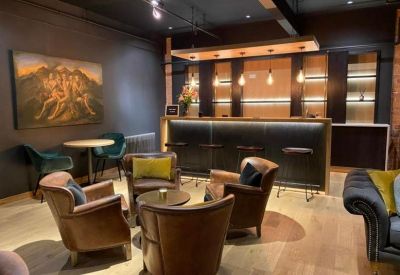 Modern bar area with leather armchairs and contemporary pendant lighting.