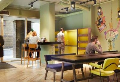 Reception area with wooden floors, stylish yellow armchairs, and whimsical wall illustrations.