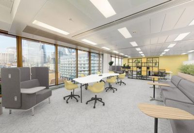 Open-plan workspace with yellow chairs, grey acoustic booths, and views of the city skyline.