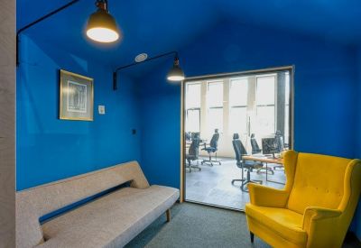 Private blue lounge room with a yellow armchair and a sofa.