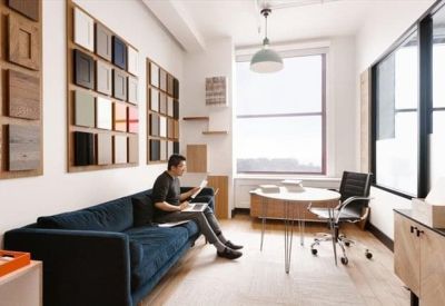 Private office with a dark blue sofa and samples wall display.