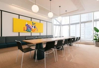 Bright meeting room with a long wooden table and vibrant yellow wall art.