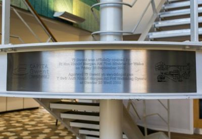 A commemorative metal plaque mounted on a white spiral staircase structure.