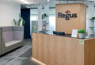 Wooden slatted reception desk with professional branding and greenery.