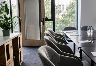 Bright conference room with grey chairs and views of the surrounding city.