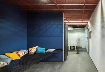 Breakout area with a low-slung black hammock bed and vibrant accent pillows.