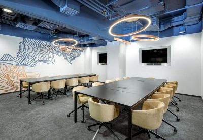 Boardroom featuring a large black table, tan leather chairs, and ring pendant lights.