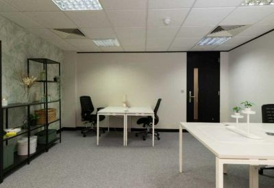 Private office suite with white desks and black ergonomic chairs.