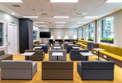 Spacious lecture-style meeting room with tiered seating and a large TV monitor.