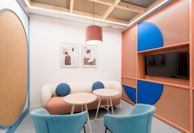 Small meeting room with coral accent walls, a white sofa, and blue cushions.