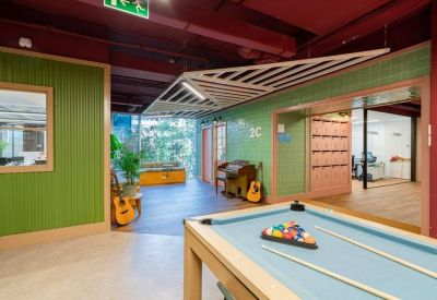 Leisure area featuring a light blue pool table, guitars, and green wood-paneled walls.
