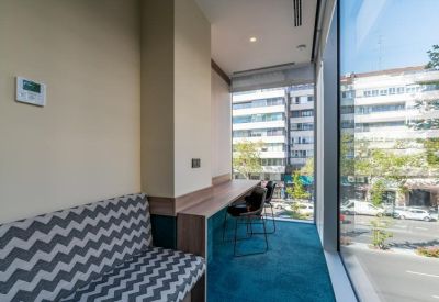 Private window-side workspace with a high bench and chevron-patterned seating.