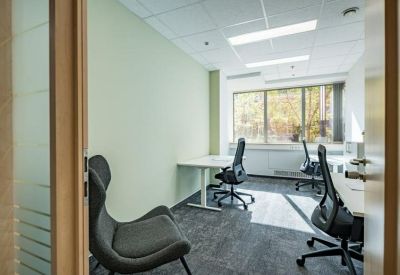 Private three-person office suite with ergonomic chairs and views of autumn trees.