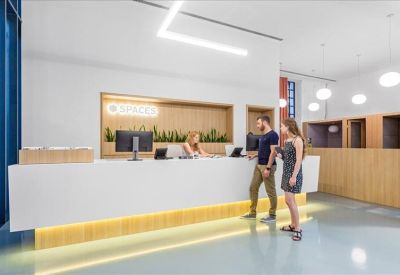 Minimalist white reception desk with warm under-lighting and wood-paneled accents.