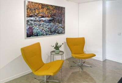 Reception area at Västra Tullgatan 6, Hudiksvall with yellow armchairs and a nature painting.