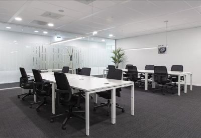 Sleek kitchenette with white cabinetry, a blue backsplash, and a built-in coffee station.
