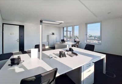 White private office suite with multiple workstations and large windows providing natural light.