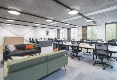 Bright coworking space with a mix of lounge seating and long white desks.