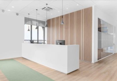 Minimalist white reception desk with wood-slatted wall paneling and hanging pendant lights.