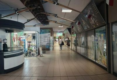 Internal corridor with a reception desk and display windows.