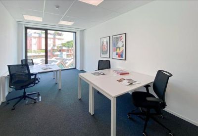 Private office suite with two white desks and views of the surrounding city.