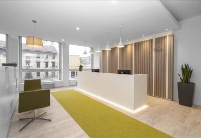 Bright reception area with white desk, yellow rug, and wood-paneled feature wall.