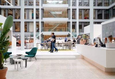 Spacious multi-level atrium with modern lounge seating and large indoor plants.