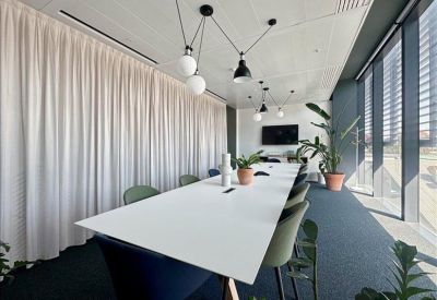 Reception area featuring a wood and stone desk with a long communal table in the background.