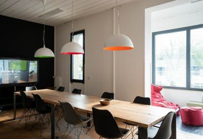 Meeting room with a long table, pendant lights, and a TV.