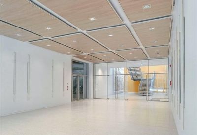 Bright, spacious lobby with high ceilings, recessed lighting, and a glass partition.