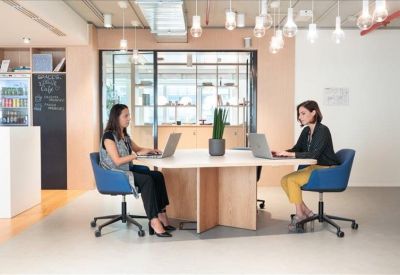 Minimalist lounge area with black chairs, a leather sofa, and a wall-mounted TV.