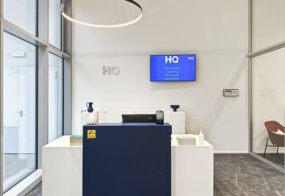 Reception area with a navy blue front desk and a hanging circular light.