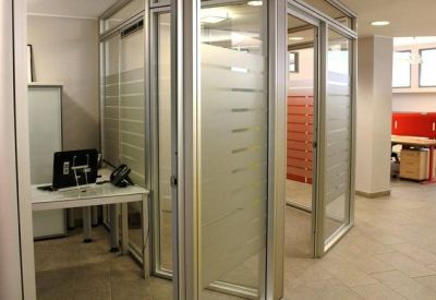 Bright reception area with glass walls and a view of a red storage unit.