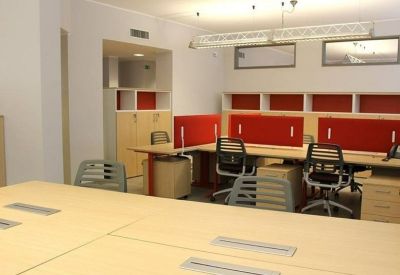 Meeting area with red acoustic panels and rows of workstations.