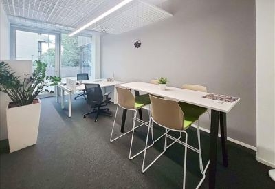 Contemporary breakout area with high-top tables and green-accented chairs.