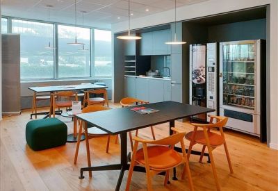 Communal kitchen and breakout area with wooden floors and vending machines.