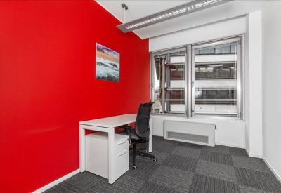 Private office with a vibrant red accent wall and white desk.