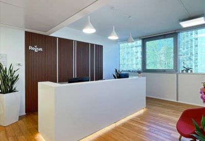 Sleek white reception desk set against a dark wood-paneled wall and warm hardwood floors.