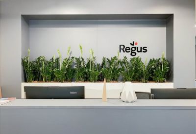 Reception area with a Regus sign and potted plants.